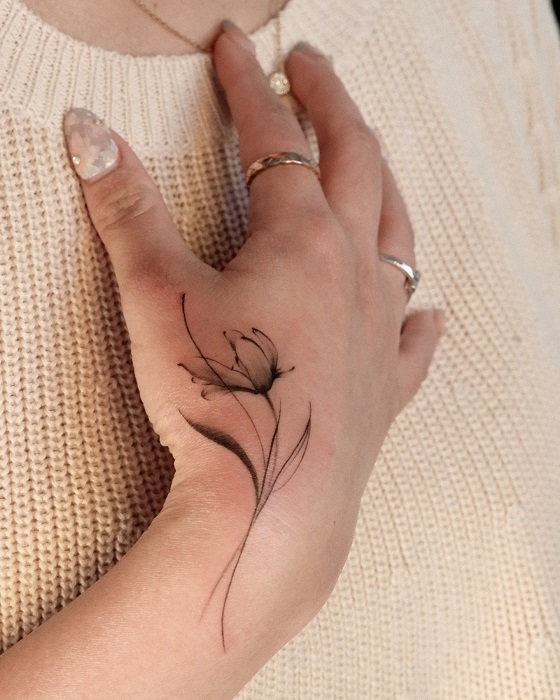minimalist magnolia hand tattoo