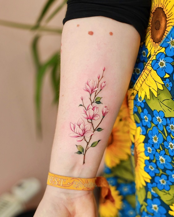delicate pink magnolia forearm tattoo