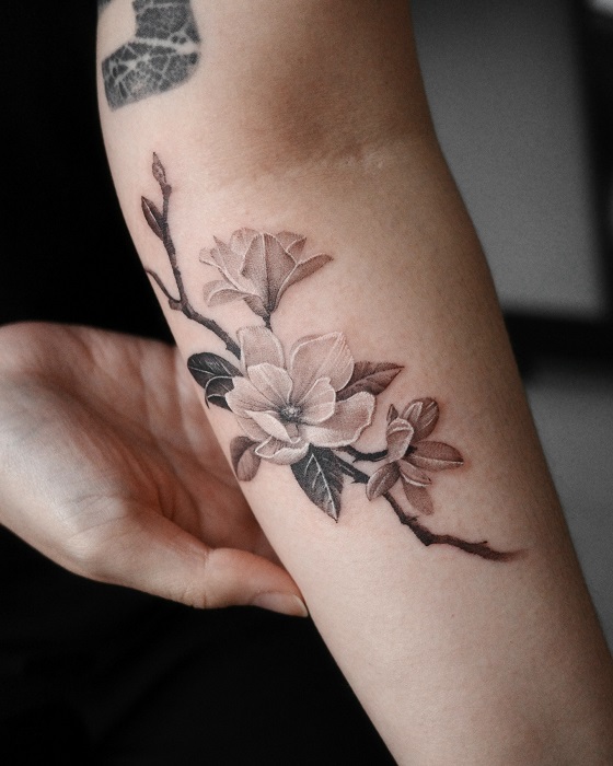 muted color magnolia inner arm tattoo