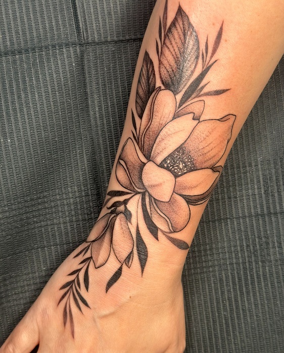 blackwork magnolia wrist and hand tattoo