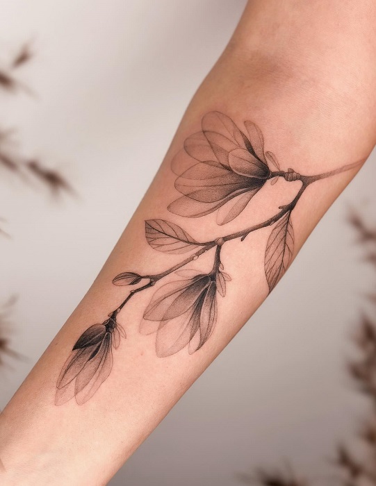 delicate magnolia branch forearm tattoo