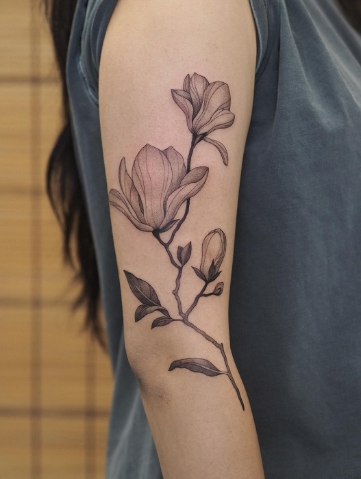 botanical magnolia upper arm tattoo