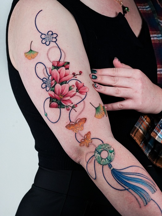 ornamental magnolia arm tattoo with tassel