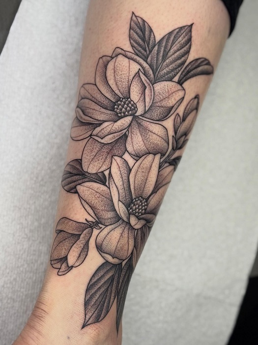 black and grey magnolia forearm tattoo