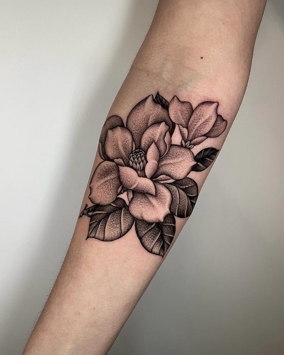 black and grey magnolia forearm tattoo